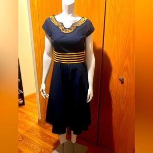 Dark navy color dress with yellow strip waist and embroiled around its neck.